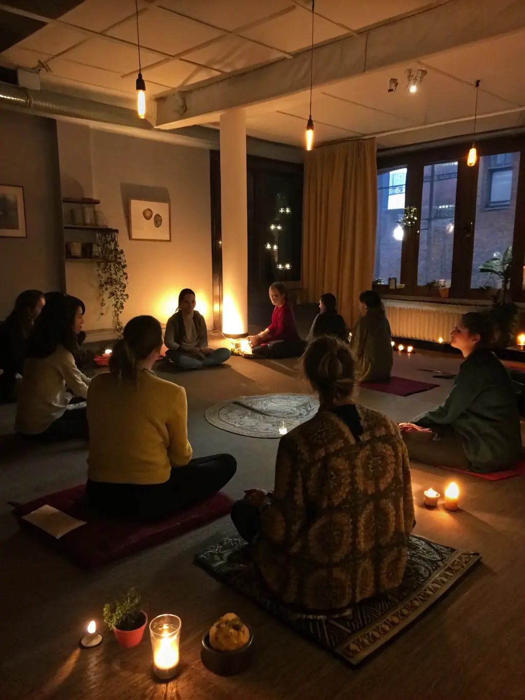 A group of people sitting in a circle during a meditation workshop, with soft lighting and calming music in the background.